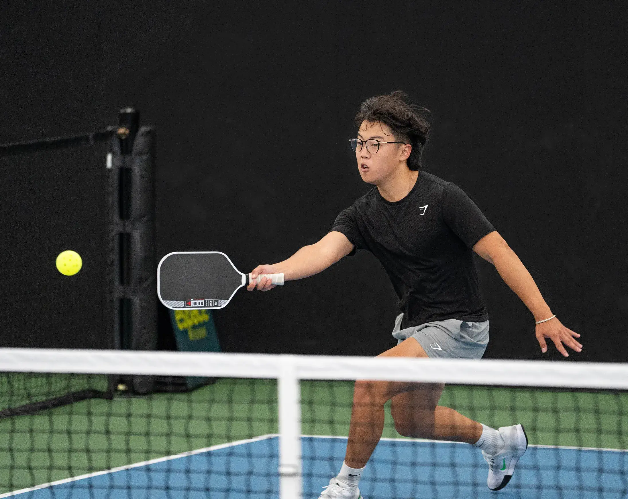 Joueur jouant sur le terrain au pickleball à l'Espace Pickleball